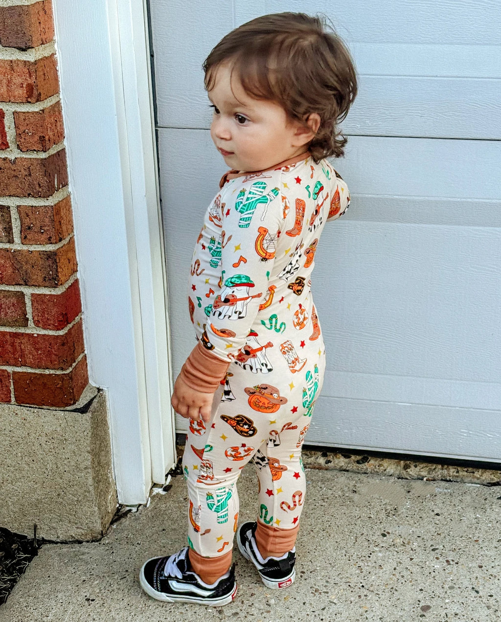 Side view of child in Howdy Halloween Bamboo Zippy showing full-body fit and western Halloween print