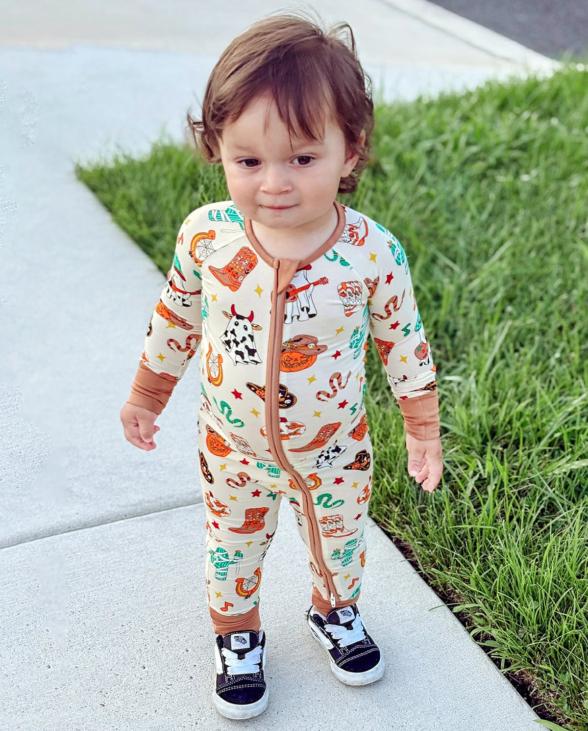 Child standing on sidewalk in Howdy Halloween Bamboo Zippy with playful cowboy Halloween pattern