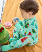 Side view of a seated baby wearing the Merry Trees Bamboo Zippy and holding a toy