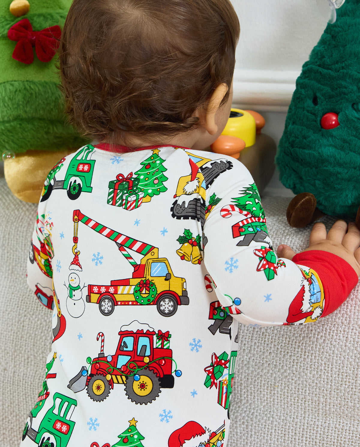 Rear close-up of the Merry Truckmas Bamboo Zippy showing a decorated crane truck, red tractor and Christmas tree beside holiday cushions.