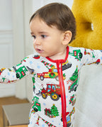 Front view of a child wearing the Merry Truckmas Bamboo Zippy, showing its red neckline, zipper and festive vehicle print.