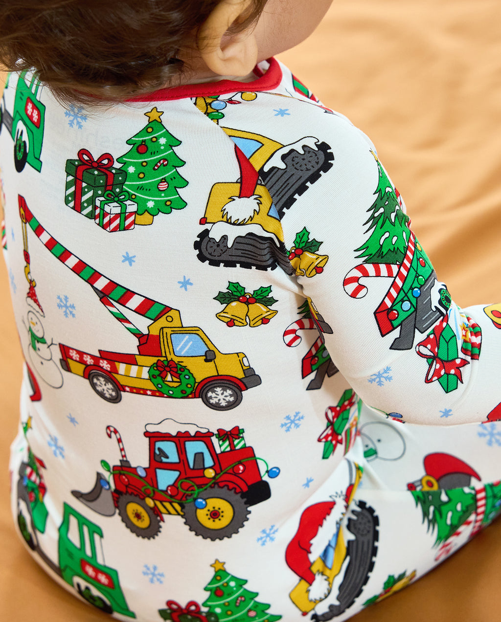Close-up of Christmas crane trucks, tractors, trees and gifts on the back of the Merry Truckmas Bamboo Zippy.