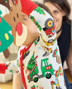 Close-up of the Merry Truckmas Bamboo Zippy with an arm raised, showing a red sleeve cuff and green truck carrying a Christmas tree.