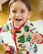 Smiling child wearing the Merry Truckmas Bamboo Zippy with a red zipper and Christmas construction-vehicle print.