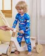 Child holding an adult hand beside a wooden toy in blue pajamas