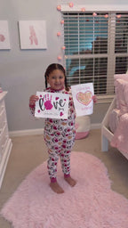 Child showing love-themed artwork while wearing matching babee Reshinee Createe Cozee custom pajamas