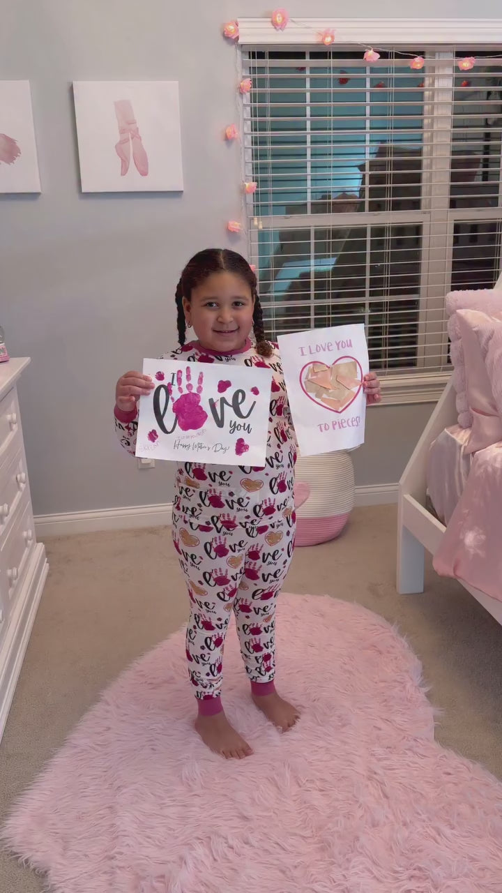 Child showing love-themed artwork while wearing matching babee Reshinee Createe Cozee custom pajamas