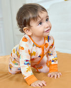 Baby crawling in Pumpkin Tractors Bamboo Zippy with orange cuffs and a pumpkin and vehicle print.