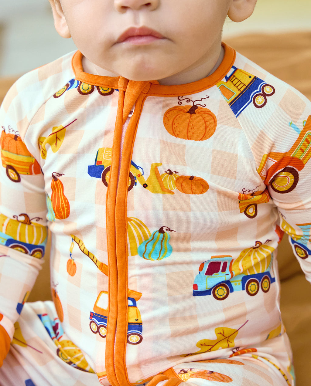 Close-up of the orange neckline and zipper on Pumpkin Tractors Bamboo Zippy.