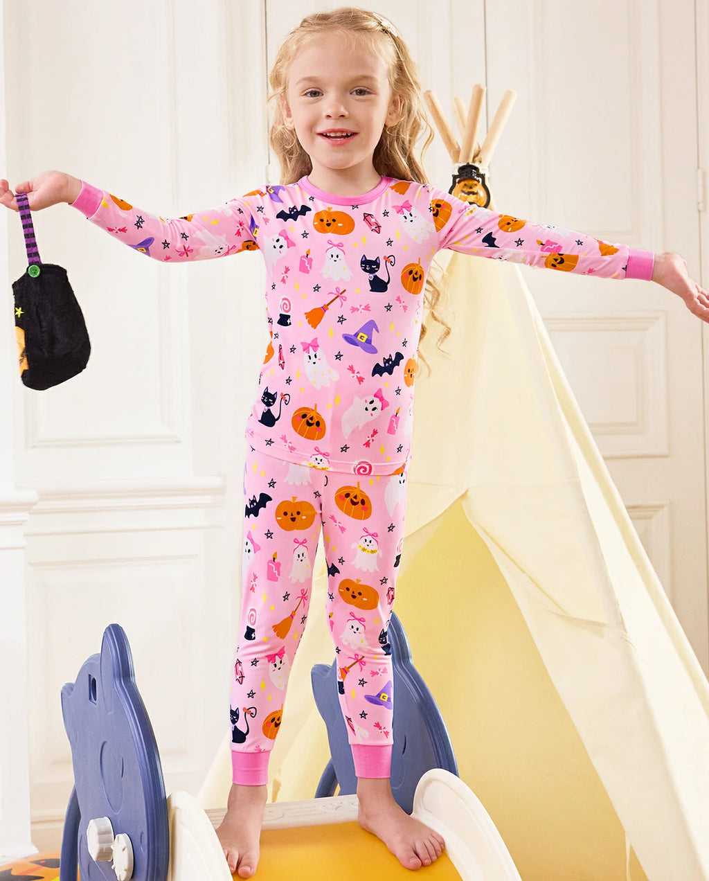 Spooky Cute Long Two-Piece Pajama Set - child wearing the pink Halloween pajamas with arms out