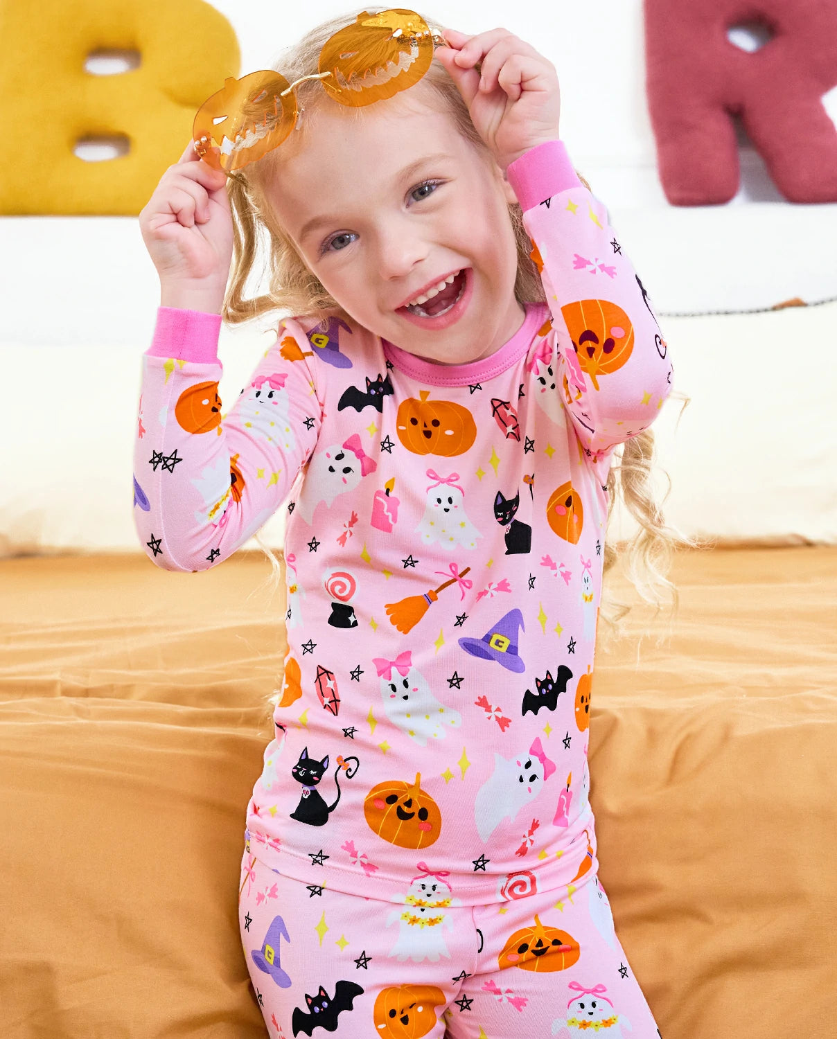 Spooky Cute Long Two-Piece Pajama Set - child wearing the pajamas while adjusting orange glasses