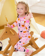 Spooky Cute Long Two-Piece Pajama Set - child wearing the pajamas on a rocking horse with a lollipop