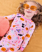 Spooky Cute Long Two-Piece Pajama Set - child wearing the pajamas while reclining in orange glasses