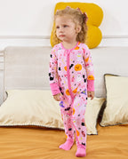 Spooky Cute Bamboo Zippy baby pajamas with pink Halloween ghost and pumpkin print in a cozy bedroom setting