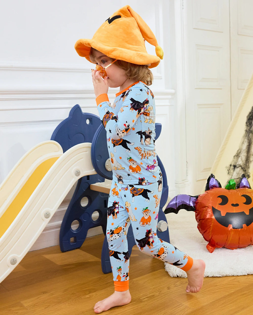 Spooky Pups Long Two-Piece Pajama Set - child wearing the pajamas while walking beside a play slide
