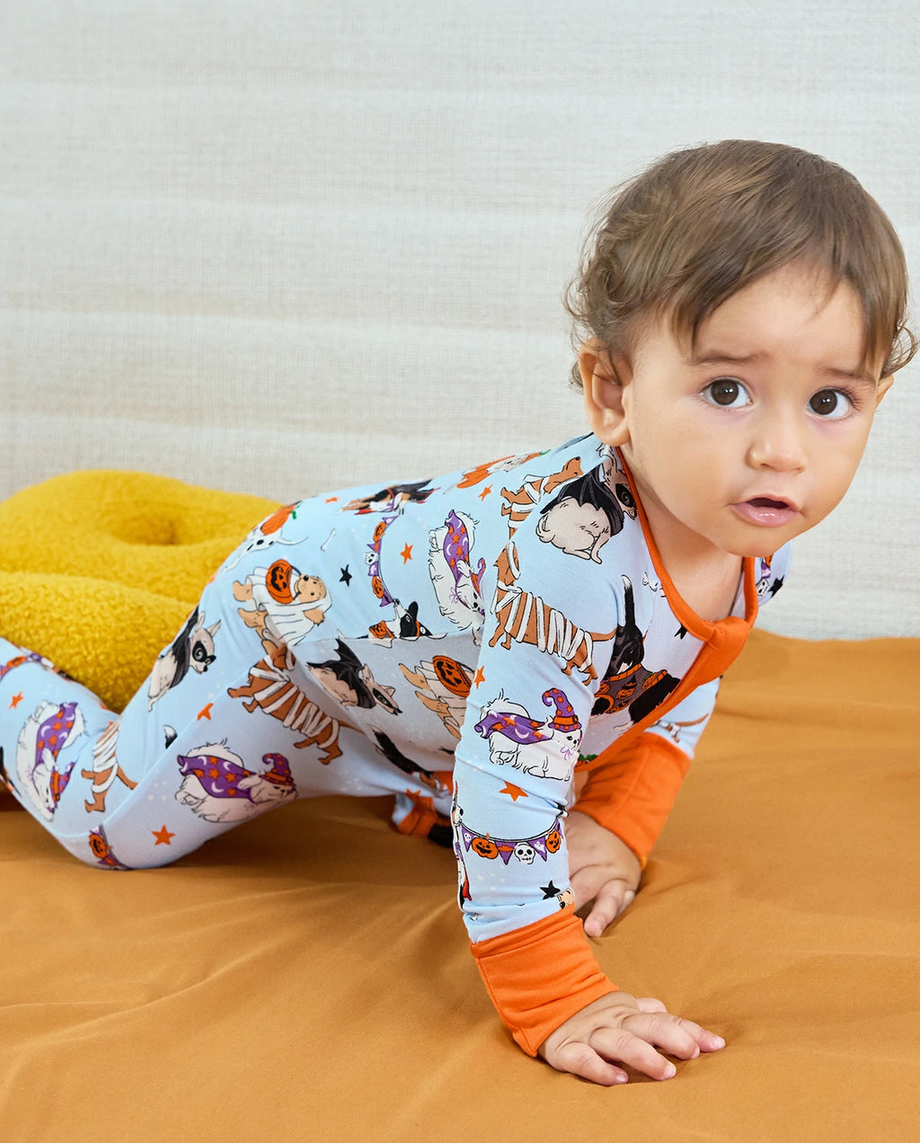 Baby crawling in Spooky Pups Bamboo Zippy on wooden floor