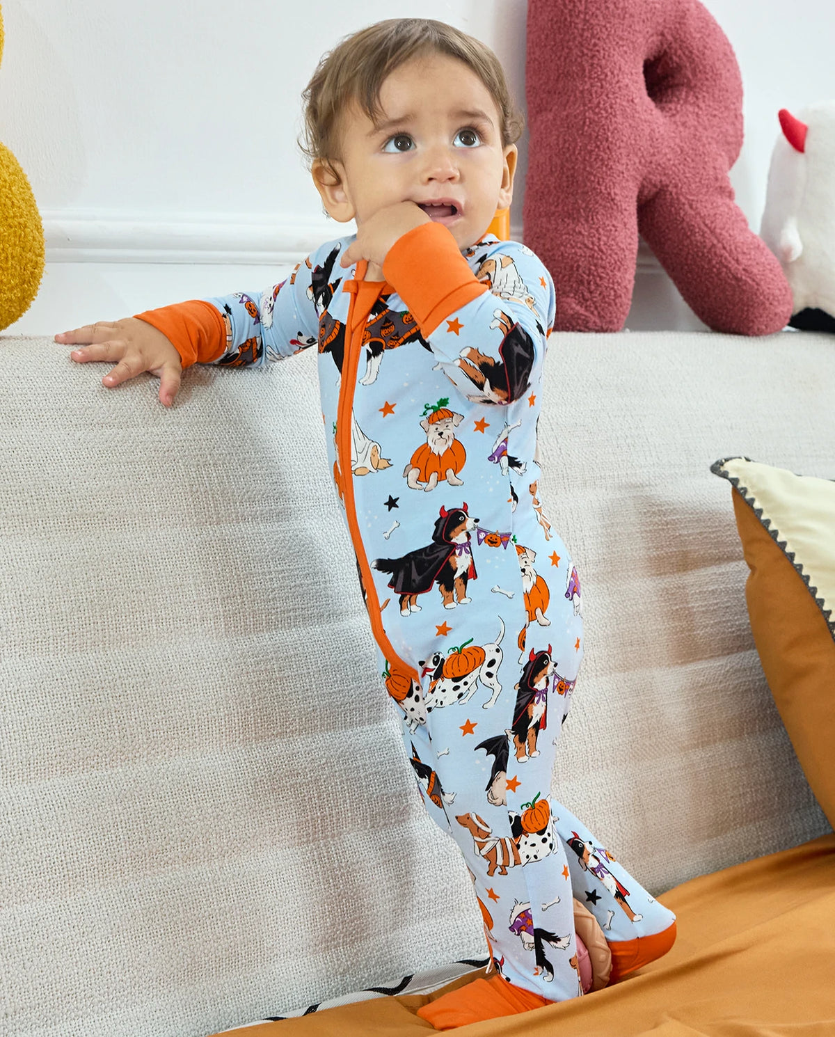 Baby standing in Spooky Pups Bamboo Zippy with Halloween dog print