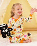 Spooky Sweet Long Two-Piece Pajama Set - child wearing the pajamas while seated with a plush spider