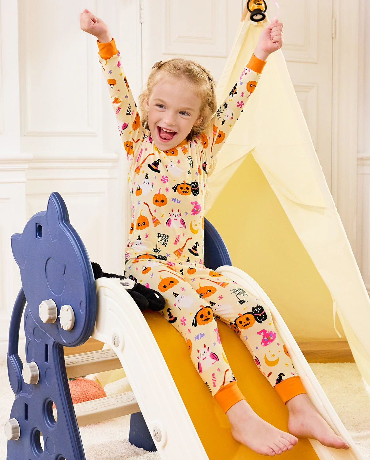 Spooky Sweet Long Two-Piece Pajama Set - child wearing the pajamas on a play slide with arms raised