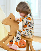 Trick Trucks Long Two-Piece Pajama Set - child wearing the pajamas while seated on a rocking horse