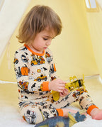Trick Trucks Long Two-Piece Pajama Set - child wearing the pajamas while seated with toy trucks