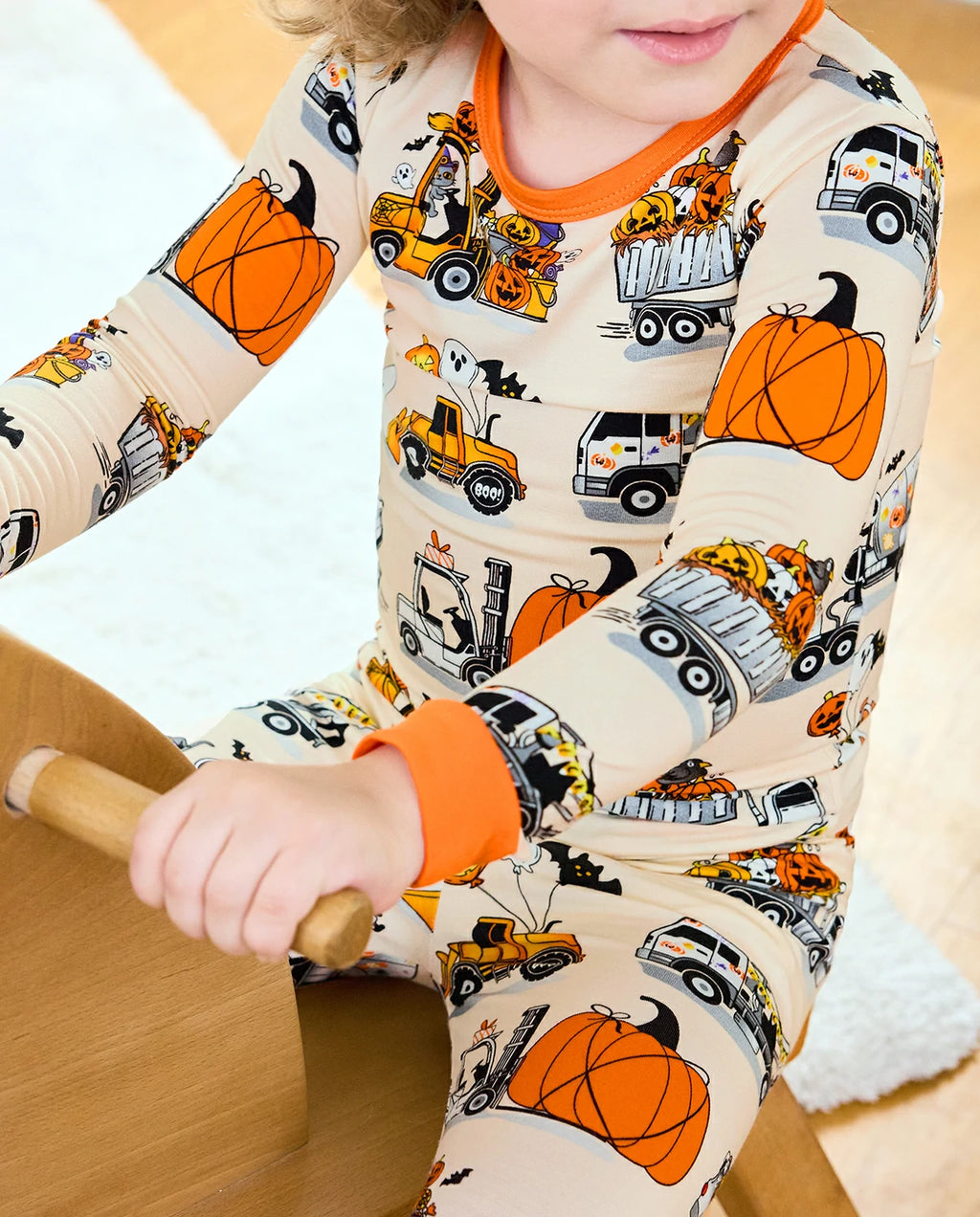 Trick Trucks Long Two-Piece Pajama Set - close-up of the truck print and orange cuffs while seated