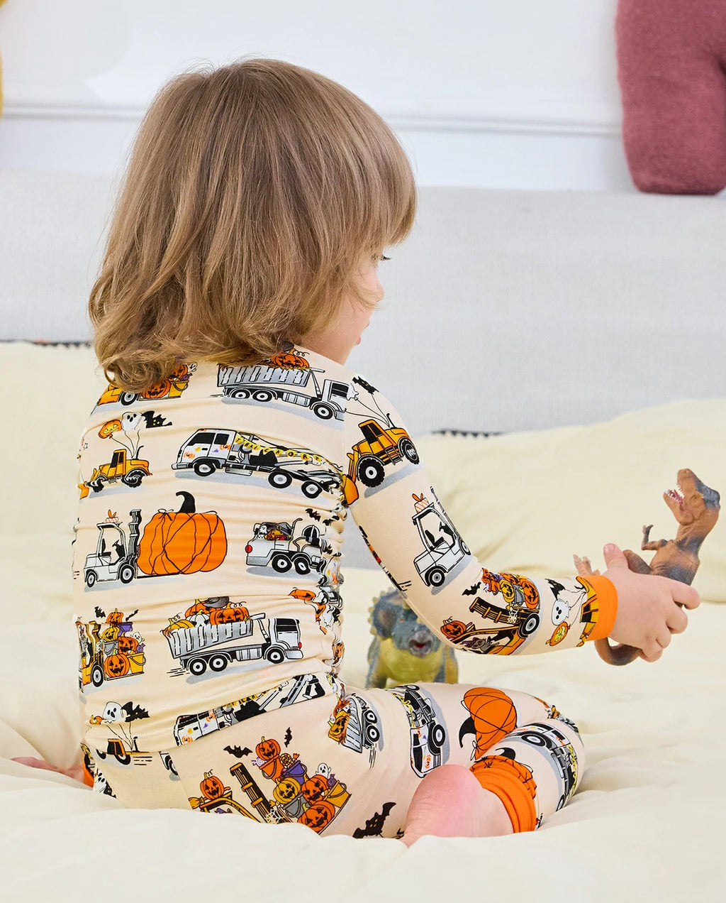 Trick Trucks Long Two-Piece Pajama Set - child wearing the pajamas while seated, back view