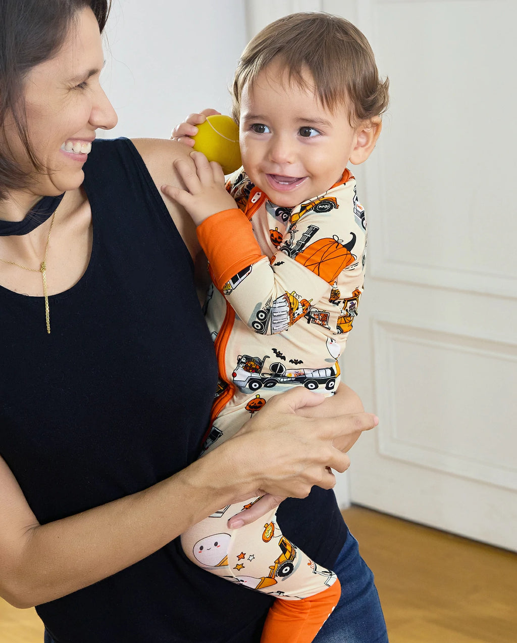 zippy-lifestyle-10.webp
Caregiver holding baby in Trick Trucks bamboo zippy with Halloween print