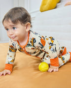 Baby crawling in Trick Trucks bamboo zippy with orange cuffs and Halloween trucks
