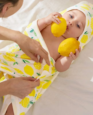 Baby wrapped in a lemon print hooded bath towel